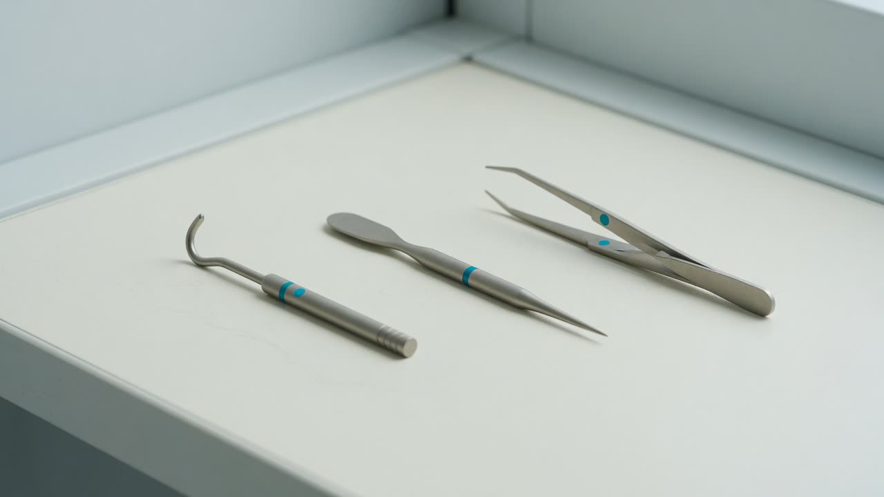 Three slim precision hand tools with cyan bands laid side by side on a white bench.
